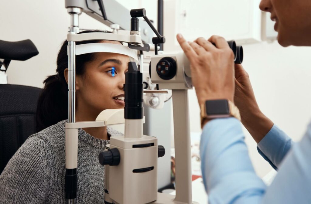 A woman has her eye examined for diseases by an optometrist during an eye exam