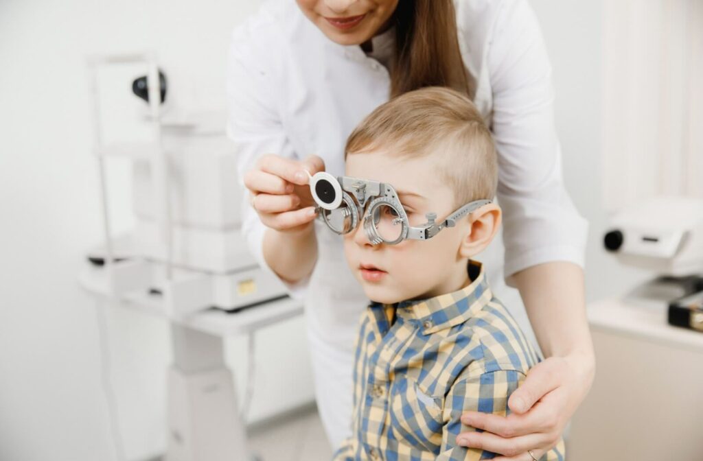 A young child wears trial frames during an eye exam.
